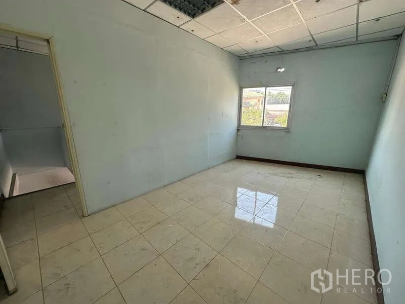 Warehouse for rent in Suan Luang, Bangkok - Second upper-floor office with window, tiled flooring and ceiling panels.