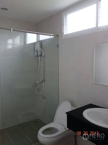 Townhouse for rent or sale in Suan Luang, Bangkok - Clean bathroom with glass-enclosed shower, toilet and vanity.