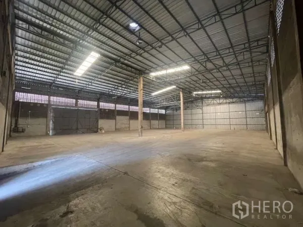 Warehouse for rent in Rat Burana, Bangkok - Open-plan storage hall with wide shutter doors, ventilation blocks and tall clear height for racking and forklift movement.