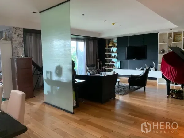 คอนโด ขายในKhlong Toei, Bangkok - พื้นที่นั่งเล่นแบบโอเพ่นพร้อมพื้นไม้ ผนังทีวี ชั้นโชว์ และประตูกระจกเปิดสู่ระเบียง