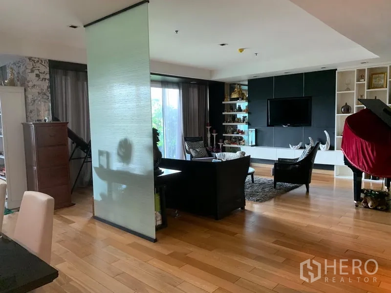 คอนโด ขายในKhlong Toei, Bangkok - พื้นที่นั่งเล่นแบบโอเพ่นพร้อมพื้นไม้ ผนังทีวี ชั้นโชว์ และประตูกระจกเปิดสู่ระเบียง