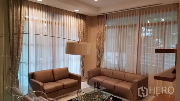 Detached House for rent or sale in Bang Phli, Samut Prakan - Bright living room with floor‑to‑ceiling sheer curtains, sofas and recessed lighting.
