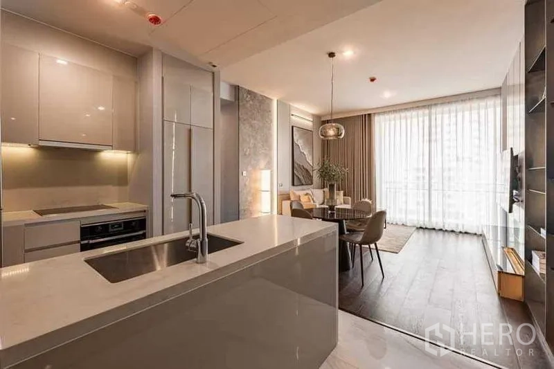 คอนโด ให้เช่า - ครัวแบบเปิดพร้อมไอส์แลนด์และเครื่องใช้บิวท์อิน เชื่อมสู่ห้องนั่งเล่นและหน้าต่างเต็มบาน