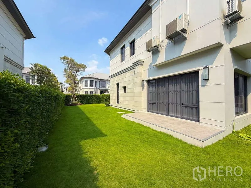 Detached House for rent or sale in Bang Kapi, Bangkok - Private backyard with lush grass, hedge fence and a side terrace.