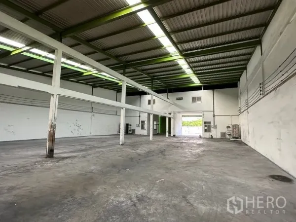 货栈 出租在Pathum Thani - 仓库内部空间开阔，钢结构高挑屋顶与天窗，耐用混凝土地面。