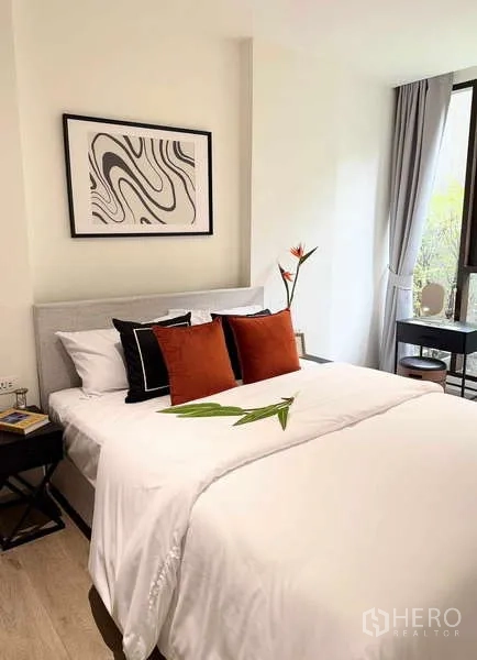 Condominium for rent - Bright bedroom with a queen bed, white linens, warm accent pillows and wall art.
