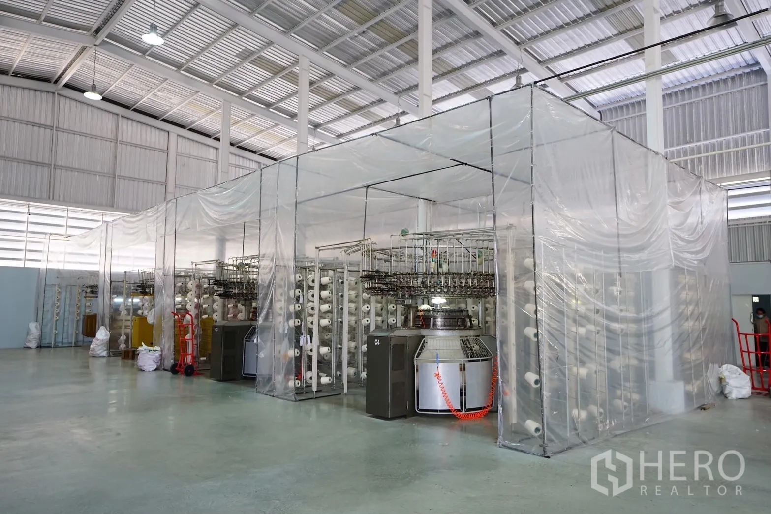 工厂 出售在Krathum Baen, Samut Sakhon - 多台纺织设备排布整齐，透明帘隔离的洁净作业区