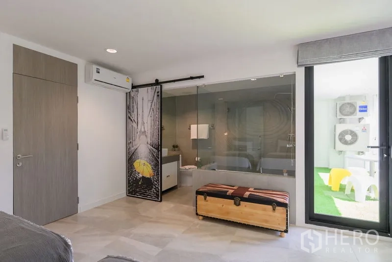 Condominium for rent in Pathum Wan, Bangkok - Guest room with glass-walled bathroom, sliding barn door, and balcony access.