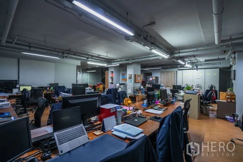 สำนักงาน ให้เช่า - พื้นที่สำนักงานแบบโอเพ่นสเปซ มีโต๊ะทำงานร่วม คอมพิวเตอร์ และไฟเพดานแบบราง