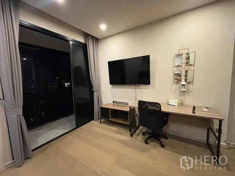คอนโด ให้เช่าในWatthana, Bangkok - มุมทำงานพร้อมโต๊ะและทีวี ข้างประตูกระจกสูงจรดเพดานเชื่อมสู่ระเบียงชมวิวกลางคืน
