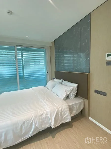 อพาร์ทเมนท์ ให้เช่าในWatthana, Bangkok - ห้องนอนหลักพร้อมผนังหัวเตียงลายหิน และประตูกระจกบานเลื่อน