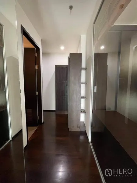 Condominium for rent or sale in Watthana, Bangkok - Hallway with mirrored wardrobes and dark wood floors.
