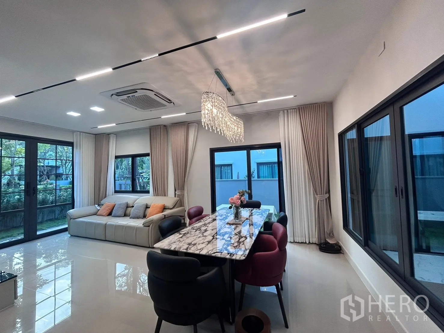 Semi-detached House for rent in Bang Phli, Samut Prakan - Open-plan living and dining room with marble table, chandelier, and garden views.