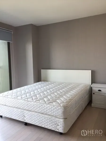 公寓 出租在Watthana, Bangkok - 明亮卧室，白色床与床头柜，墙面中性色调，环境清爽。