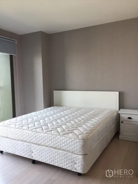 公寓 出租在Watthana, Bangkok - 明亮卧室，白色床与床头柜，墙面中性色调，环境清爽。