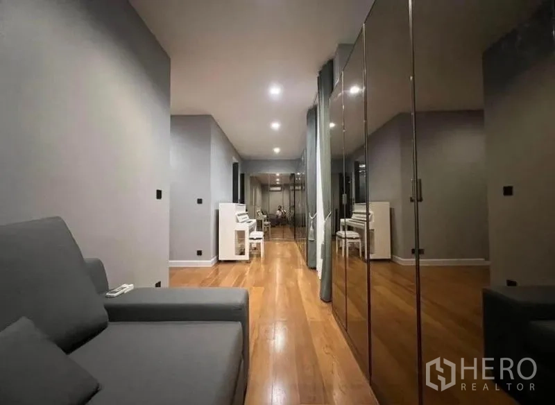 独立式住宅 出租 - 长走廊起居区，木地板与镜面衣柜，一端可见钢琴，现代风格别墅室内.