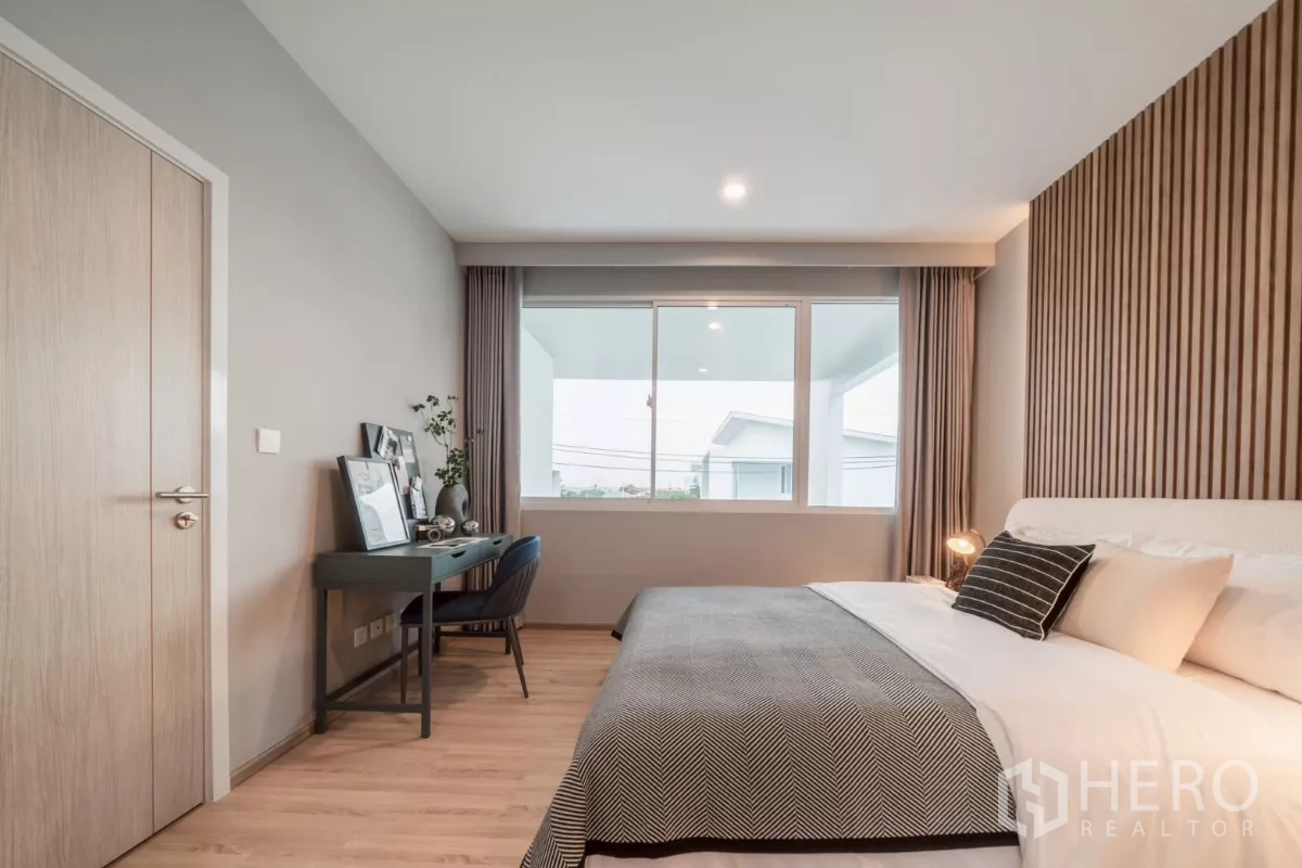 บ้าน ให้เช่าในSaphan Sung, Bangkok - ห้องนอนเตียงคิง ผนังตกแต่งซี่ไม้และโต๊ะทำงานริมหน้าต่างกว้าง