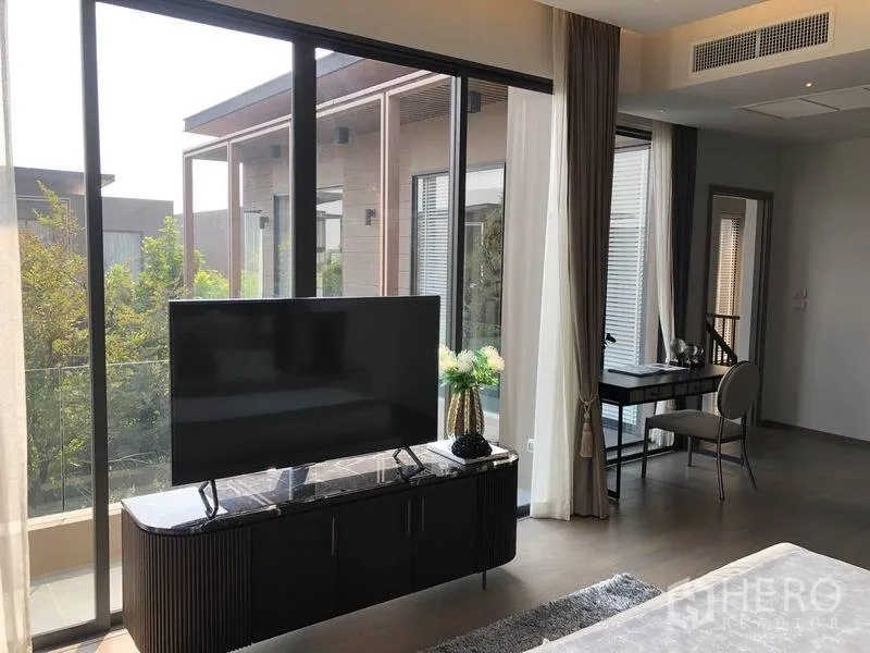 独立式住宅 出售在Bang Kapi, Bangkok - 主卧一角设电视柜、落地窗、阳台与学习角。