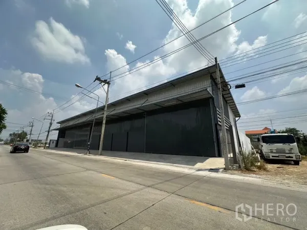คลังสินค้า ให้เช่าในLam Luk Ka, Pathum Thani - ด้านหน้าโกดังติดถนน ประตูบานสไลด์ขนาดใหญ่และพื้นที่ลานโหลดสินค้า ที่ลำลูกกา