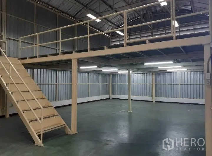 Warehouse for rent in Bang Kho Laem, Bangkok - Warehouse interior highlighting the mezzanine, stairway, and smooth concrete floor.