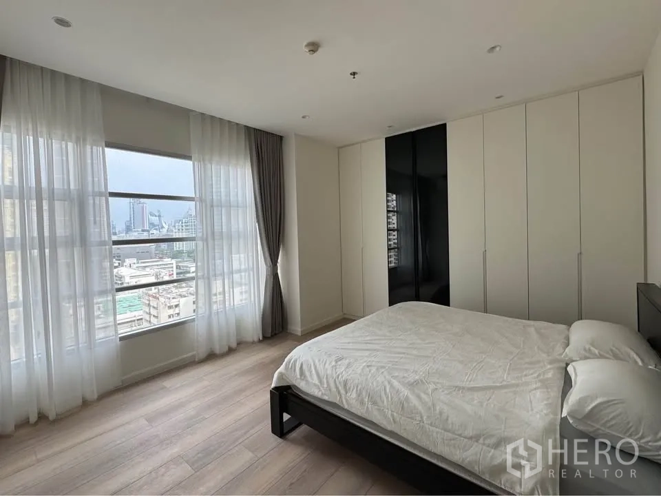 คอนโด for rent in Ratchathewi, Bangkok - ห้องนอนหลักหน้าต่างกว้าง วิวสกายไลน์ และตู้เสื้อผ้าแนวยาว