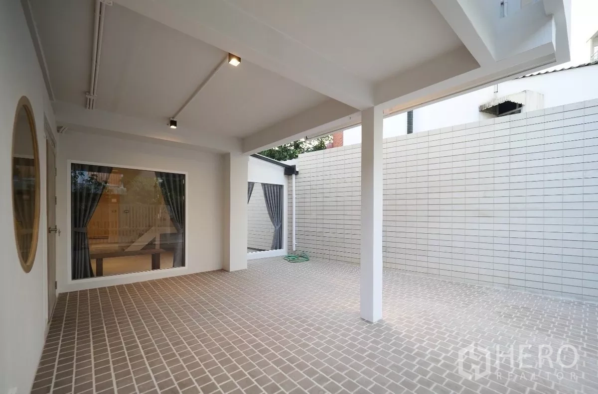 联排别墅 出租或出售在Watthana, Bangkok - 遮蔽式露台与私密围墙庭院，配大窗与壁灯。