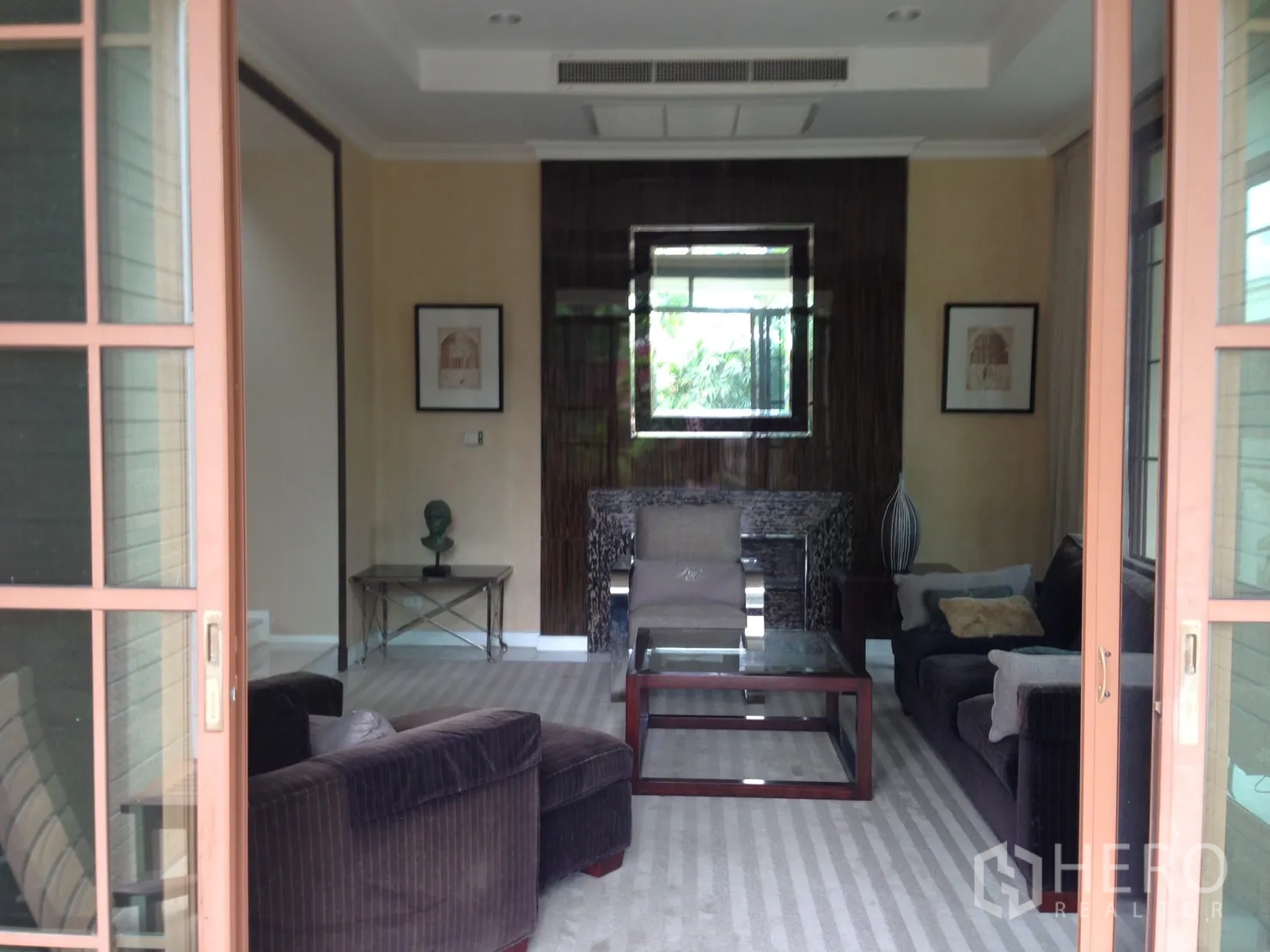 Detached House for rent or sale in Suan Luang, Bangkok - Cozy living room with sliding glass doors, sofa set and feature wall.
