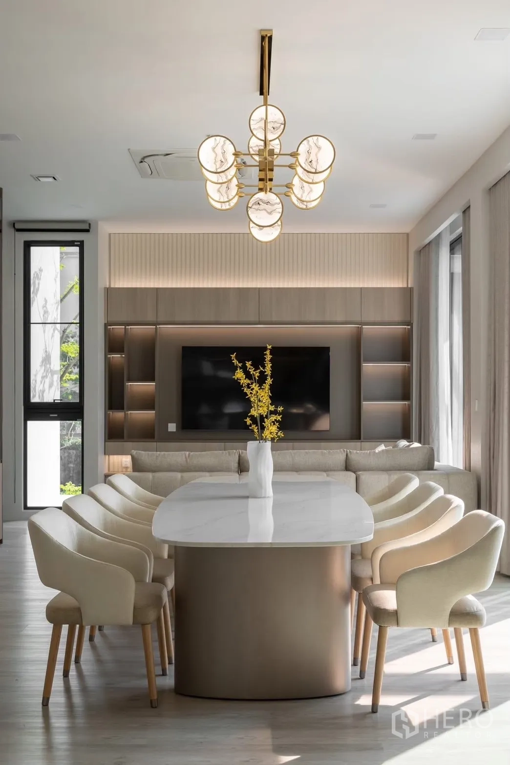 Detached House for rent in Saphan Sung, Bangkok - Dining table facing TV wall and sofa in a contemporary neutral lounge.