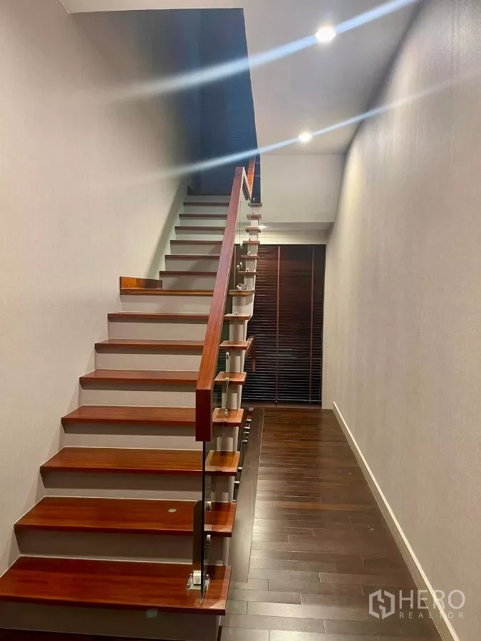 ทาวน์เฮาส์ ให้เช่าในChatuchak, Bangkok - บันไดไม้ราวกระจกตามโถงทางเดิน ไฟดาวน์ไลท์และพื้นไม้จริง