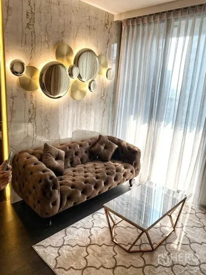 คอนโด ให้เช่าหรือขายในWatthana, Bangkok - ห้องนั่งเล่นอบอุ่น โซฟากำมะหยี่ทรงวินเทจ ผนังตกแต่งวงกลมสีทอง โต๊ะกลางกระจกและผ้าม่านโปร่ง