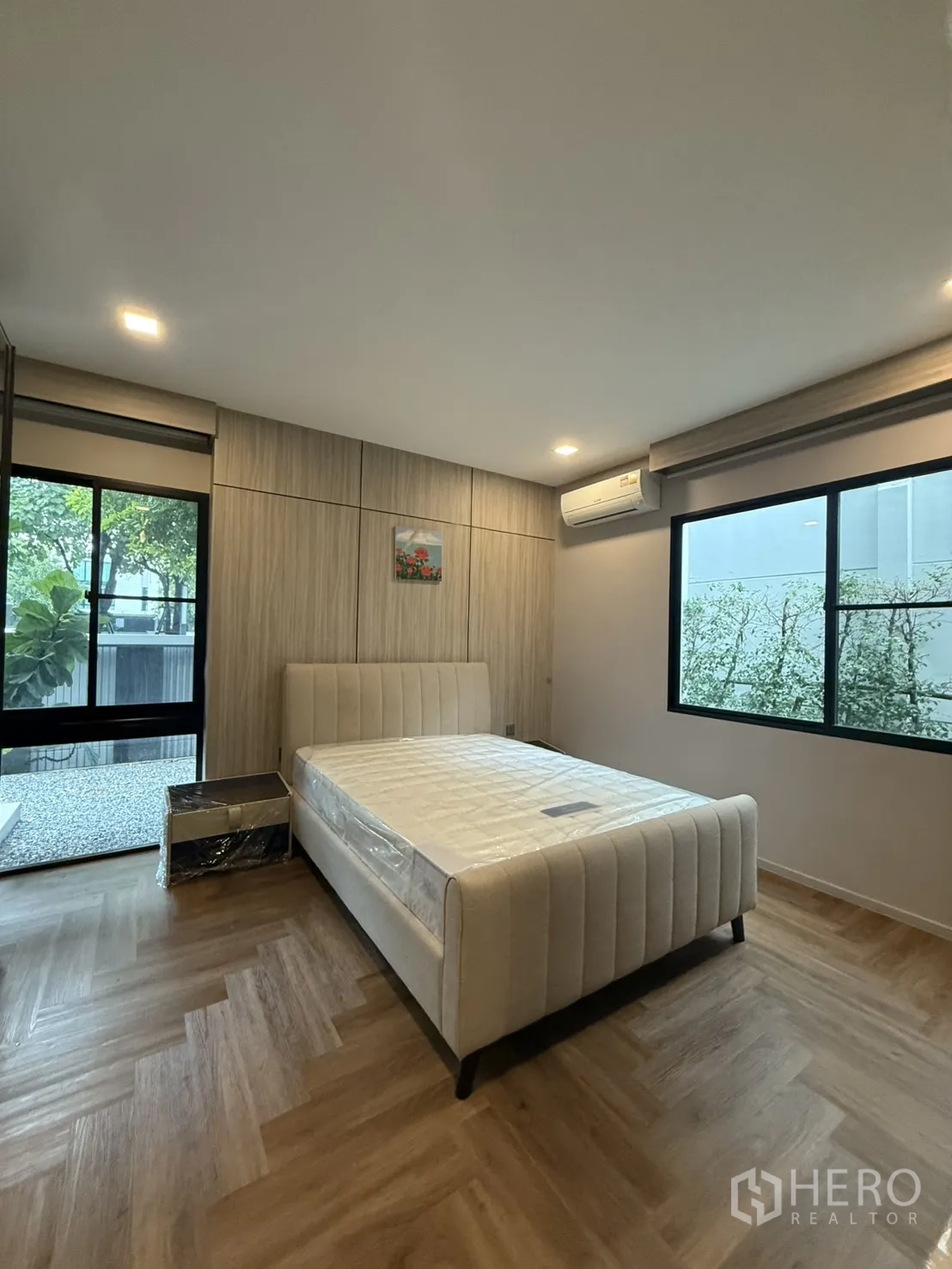Detached House for rent in Saphan Sung, Bangkok - Bedroom with large windows, air-conditioning and wood floors.