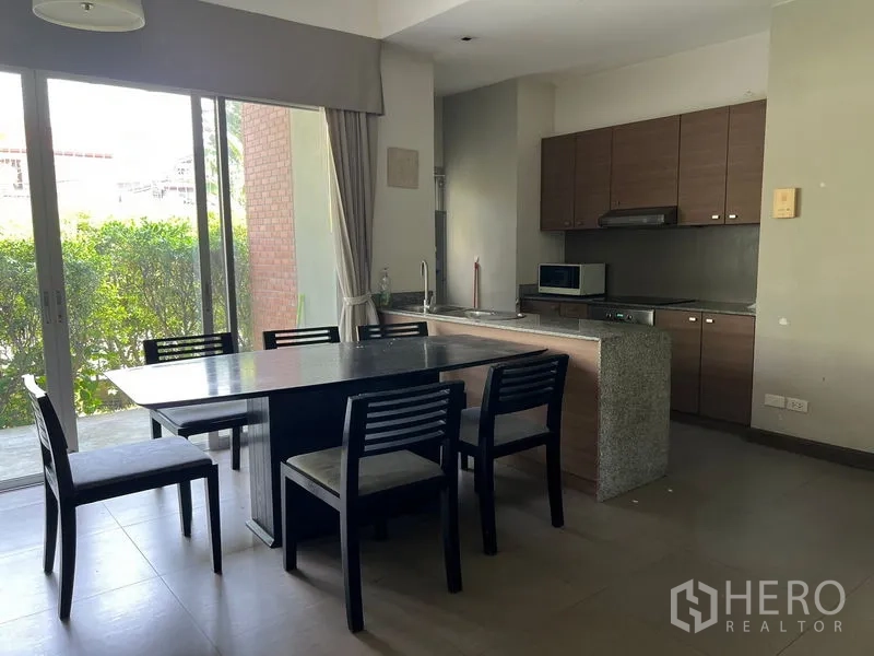 อพาร์ทเมนท์ ให้เช่าในWatthana, Bangkok - ครัวเปิดพร้อมตู้ลายไม้ เคาน์เตอร์หินและโต๊ะทานอาหารติดประตูกระจกบานเลื่อน