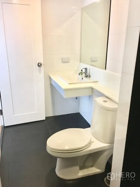 คอนโด ให้เช่าในWatthana, Bangkok - ห้องน้ำโทนขาวสะอาดพร้อมเคาน์เตอร์อ่างล้างหน้า กระจก และโถสุขภัณฑ์