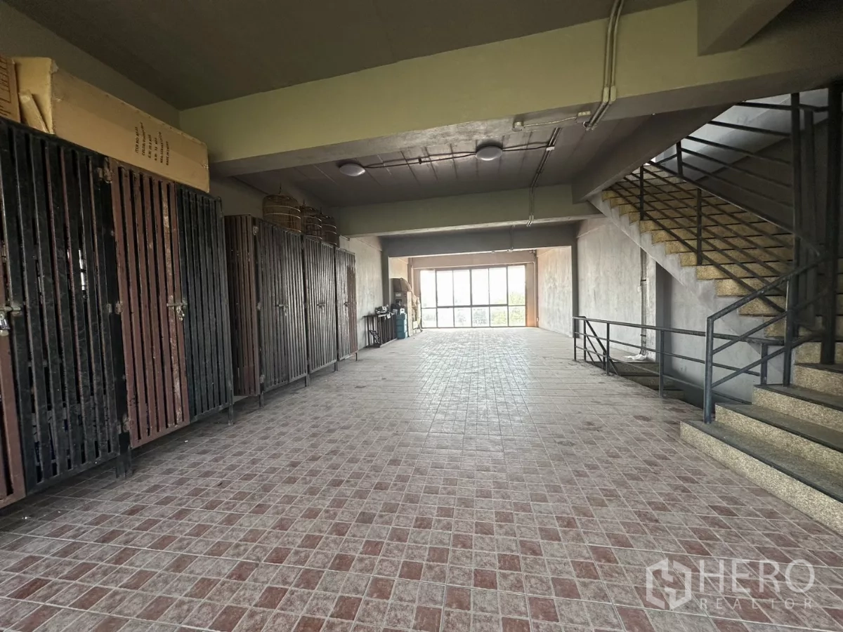 店屋 出租在Bang Na, Bangkok - 深进深楼层，一侧为储物柜，楼梯通往更高楼层。