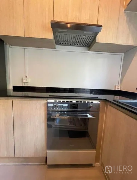 Townhouse for rent in Yan Nawa, Bangkok - Close-up of built-in oven and range hood in the modern kitchen.