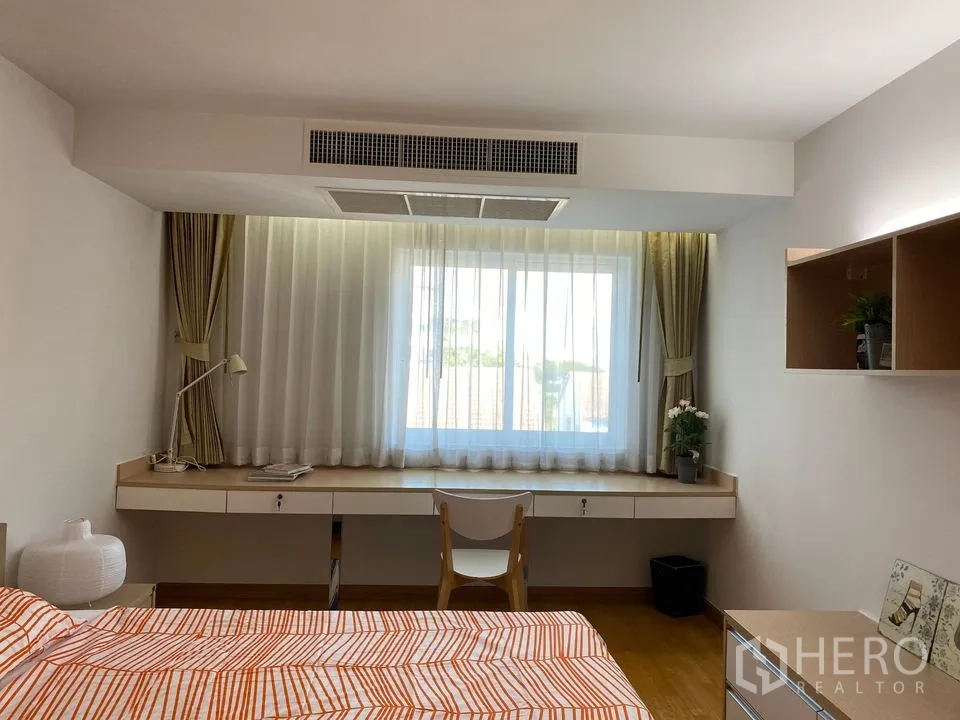 Condominium for rent or sale in Phra Khanong, Bangkok - Workstation by a wide window with sheer curtains and ducted air-conditioning vent.