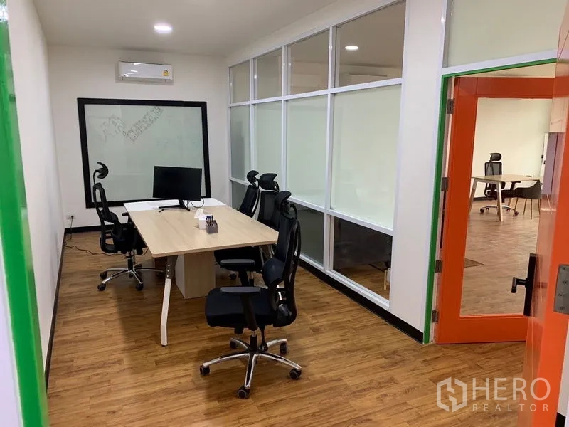 Office Space for rent in Khlong Toei, Bangkok - Glass-partition meeting room with ergonomic chairs and a work desk beside an orange door.