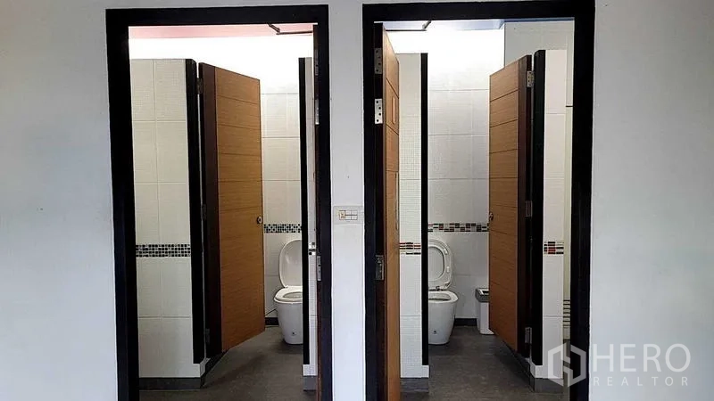 工厂 出售在Saphan Sung, Bangkok - 卫生间，两间独立隔间，白色墙砖与木门。