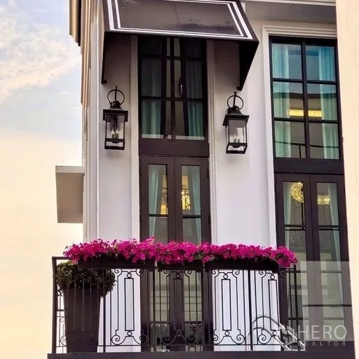 Townhouse for sale - Townhouse balcony with French doors, lantern lights and pink flower planters.