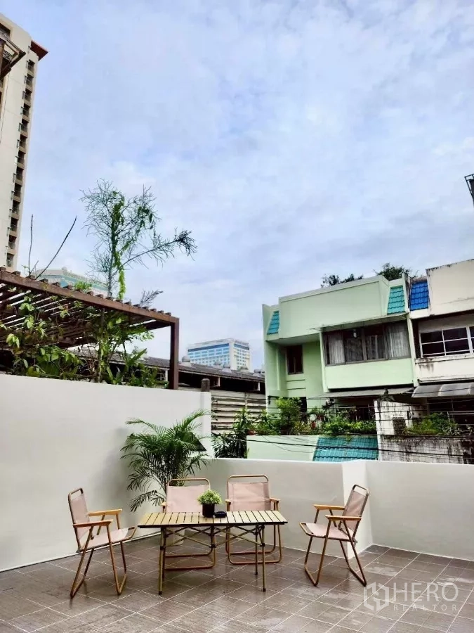ทาวน์เฮาส์ ให้เช่าในHuai Khwang, Bangkok - ระเบียงเทอเรสกลางแจ้ง ชุดโต๊ะเก้าอี้และกระถางต้นไม้ พร้อมกำแพงกันสายตา