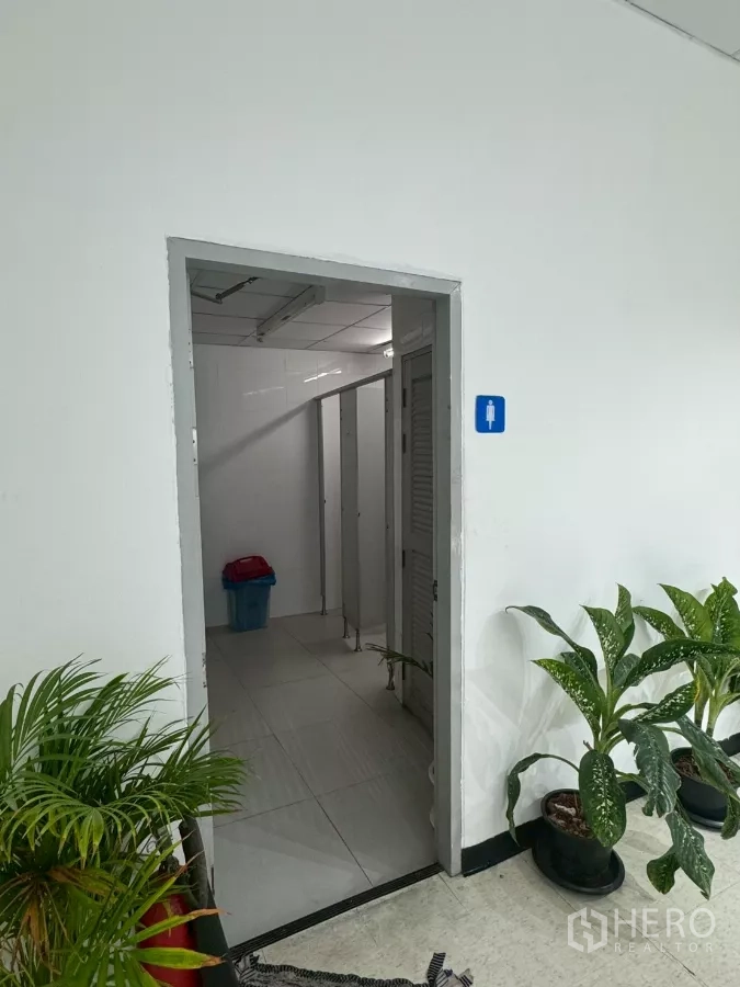 Shophouse for rent in Samphanthawong, Bangkok - Entrance to restroom with potted plants by the doorway.