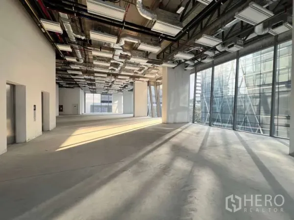 办公空间 出租 - 充满阳光的转角办公区，通高玻璃墙与开放式天花，适合二次装修