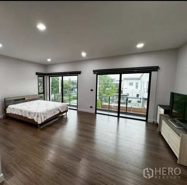 บ้าน ให้เช่าหรือขายในLat Krabang, Bangkok - ห้องนอนมาสเตอร์กว้างพื้นลามิเนตไม้ ประตูกระจกบานเลื่อนเปิดออกสู่ระเบียง.