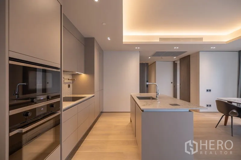 คอนโด ให้เช่าในPathum Wan, Bangkok - ครัวตัวแอลอุปกรณ์ครบ ไอส์แลนด์หินอ่อน และไฟบรรยากาศอบอุ่น