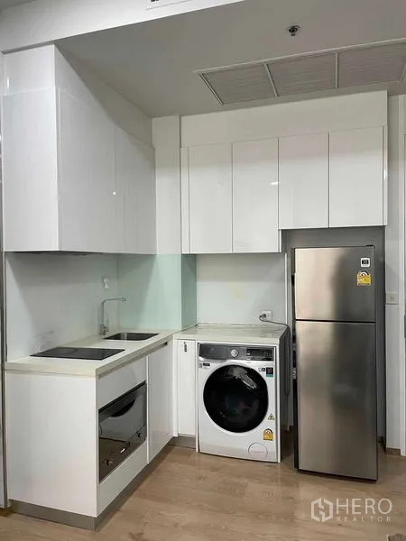 คอนโด ให้เช่าในWatthana, Bangkok - ครัวสีขาวกะทัดรัด เตาไฟฟ้า เตาอบ อ่างล้างจาน และเครื่องซักอบ
