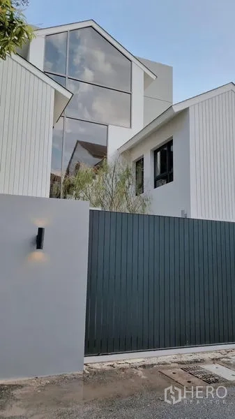 บ้าน ให้เช่าในKhlong Toei, Bangkok - ภายนอกบ้านทรงจั่วสไตล์โมเดิร์น หน้าต่างสูง หลังรั้วประตูสูงเพื่อความเป็นส่วนตัว