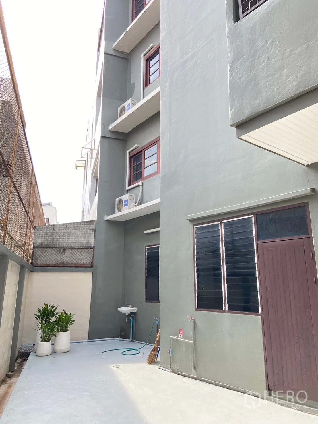 Home Office for rent in Watthana, Bangkok - Exterior facade with ornate white metal gate and balconies of a multi-storey building.