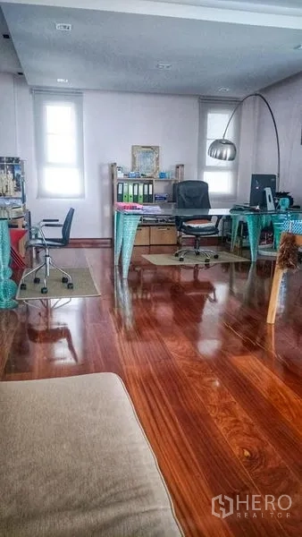 Home Office for sale in Phasi Charoen, Bangkok - Open-plan home office area with desks, swivel chairs and glossy wooden flooring.