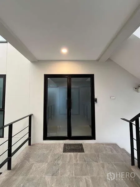 Office Space for rent in Prawet, Bangkok - Entrance landing with black-framed sliding glass door under a covered area.