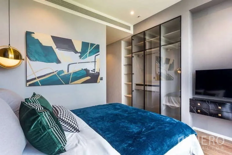 Condominium for rent in Pathum Wan, Bangkok - Master bedroom with glass wardrobe and wall-mounted TV.